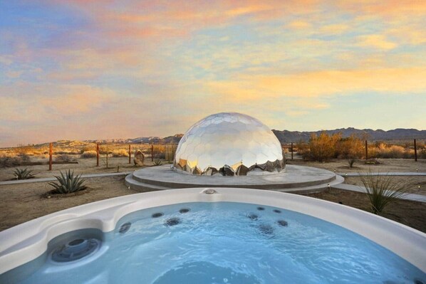 A hot tub with a dome-shaped structure in the background.