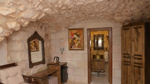 A rustic room with stone walls, a wooden desk, a bed, and a wardrobe. - Mehmet Bey Konağı Butik Otel (Midyat)