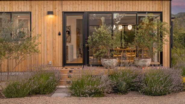 A modern wooden house with large glass doors, a garden with lavender, and a view of the surrounding landscape. - Calistoga Wine Ranch Estate (Calistoga)