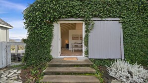 Une maison avec un escalier en pierre menant à une porte sur laquelle est posé un paillasson avec l’inscription « Bienvenue ».