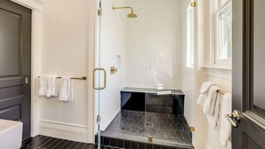 A modern bathroom with a glass shower enclosure, a black tiled floor, and white walls. - Casa Rosa in St Helena (St. Helena)