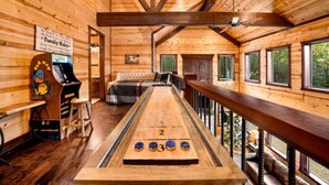 Ein Schiebetisch in einer Holzhütte mit einem Schild über Familienregeln, einer Couch und Blick ins Freie.