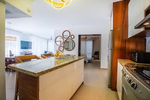 Una cocina moderna con una isla central, armarios de madera y una estufa integrada.