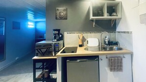 Una cocina compacta equipada con lavavajillas, cafetera, tostadora y pileta.