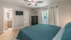 A bedroom with a bed, a ceiling fan, a television, a dresser, and a window with curtains. - No Cleaning Fee!!~King Bed~Near Dickies,TCU, cultural district~Sleeps 6 (Fort Worth)