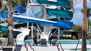 Un parc aquatique doté de nombreux toboggans et d’un espace piscine avec des chaises longues.