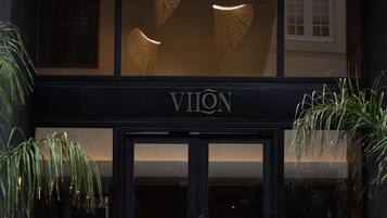 A man standing in front of a building with the sign "VION" and a large glass entrance.