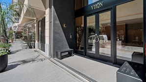 Un escaparate con diseño moderno, que incluye una amplia entrada de vidrio y un parquímetro a la vista.