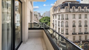 A balcony with a glass railing overlooking a cityscape with historic buildings. - Vilon Recoleta Hotel (Buenos Aires)