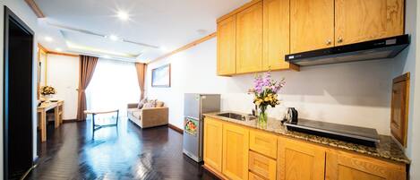 A modern kitchen with wooden cabinets, a stainless steel sink, and a refrigerator.
