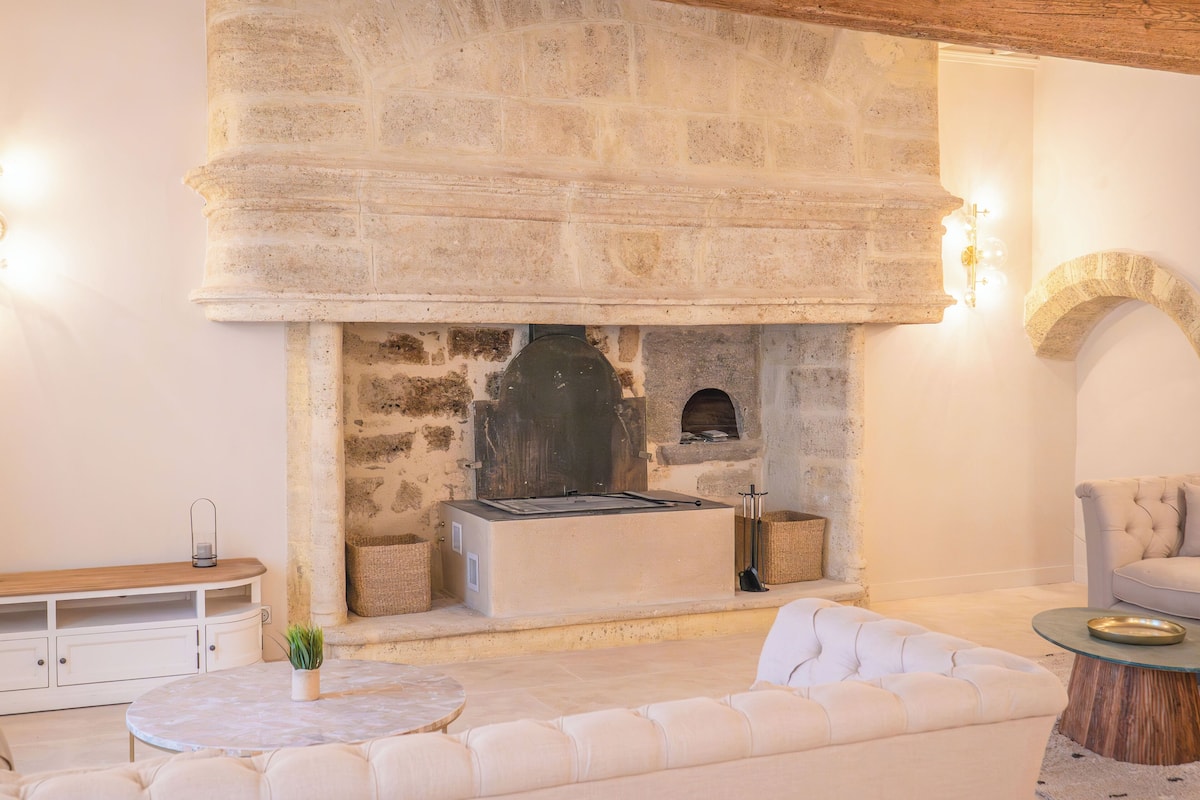 A stone fireplace with a built-in oven, a cushioned seating area, and a wooden bench.