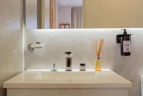 A bathroom with a white sink, a mirror, and a soap dispenser. - Porto by FMA Coliving (Villa San Lorenzo)