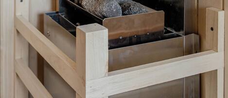 Un mueble de almacenamiento de madera con un estante metálico que sostiene varias rocas de color oscuro.