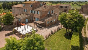 Un bâtiment traditionnel en briques, doté de nombreuses fenêtres et d’une cour intérieure.
