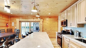 Una cocina moderna con paneles de madera, una isla central y electrodomésticos integrados.