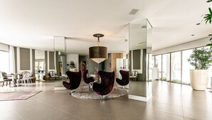 A spacious living area with a modern chandelier, a round rug, and a large potted plant. - WI-FI 100MB | 55" Smart TV | 350m from Beach #JA33 (Florianópolis)
