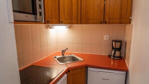A compact kitchen with a sink, a coffee maker, and a dishwasher. - 40m from ski slopes, 1st floor, view mountain, fitness, swimming pool, sauna, balcony, tv (Les Orres)