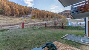 Une terrasse offrant une vue sur une colline boisée et une rivière.