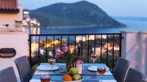 A table set for two with wine glasses, a bottle of Sava wine, and a bowl of fruit. - Elena Is A Contemporary, Spacious Apartment Within The Stunning Elvina Complex (Kalkan, Antalya)