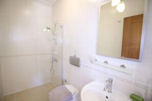 A bathroom with a shower, toilet, sink, and a mirror. - Elena Is A Contemporary, Spacious Apartment Within The Stunning Elvina Complex (Kalkan, Antalya)