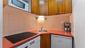 A compact kitchen with a microwave, a sink, a coffee maker, and a dishwasher. - 40m from ski slopes, 2nd floor, view mountain, fitness, swimming pool, sauna, balcony, tv (Les Orres)