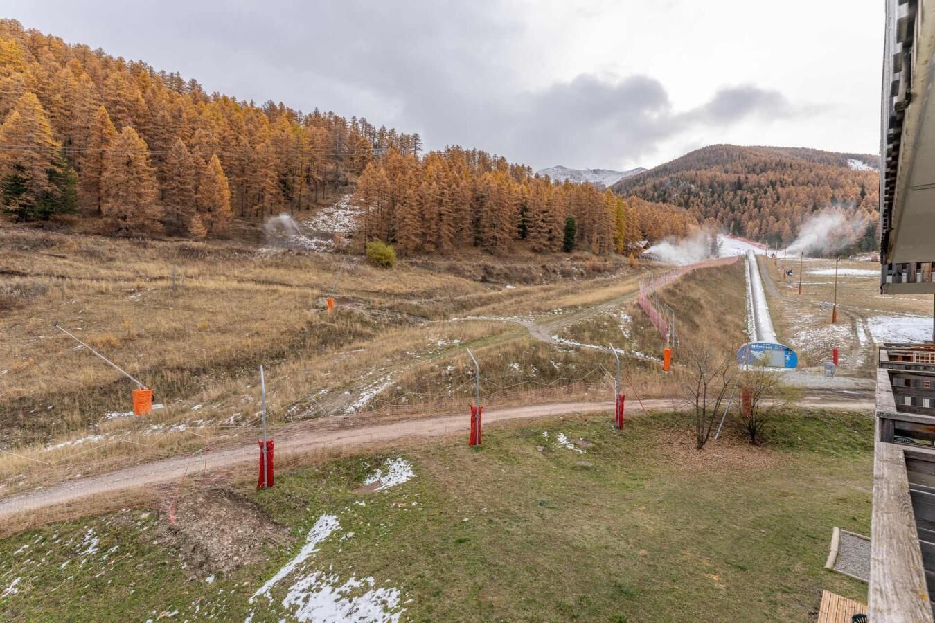 Blick auf eine Berglandschaft mit einer Seilbahn und einem Weg zu einer Berghütte.