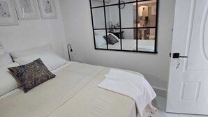 Una camera da letto con un letto, un comodino, uno specchio e una porta.
