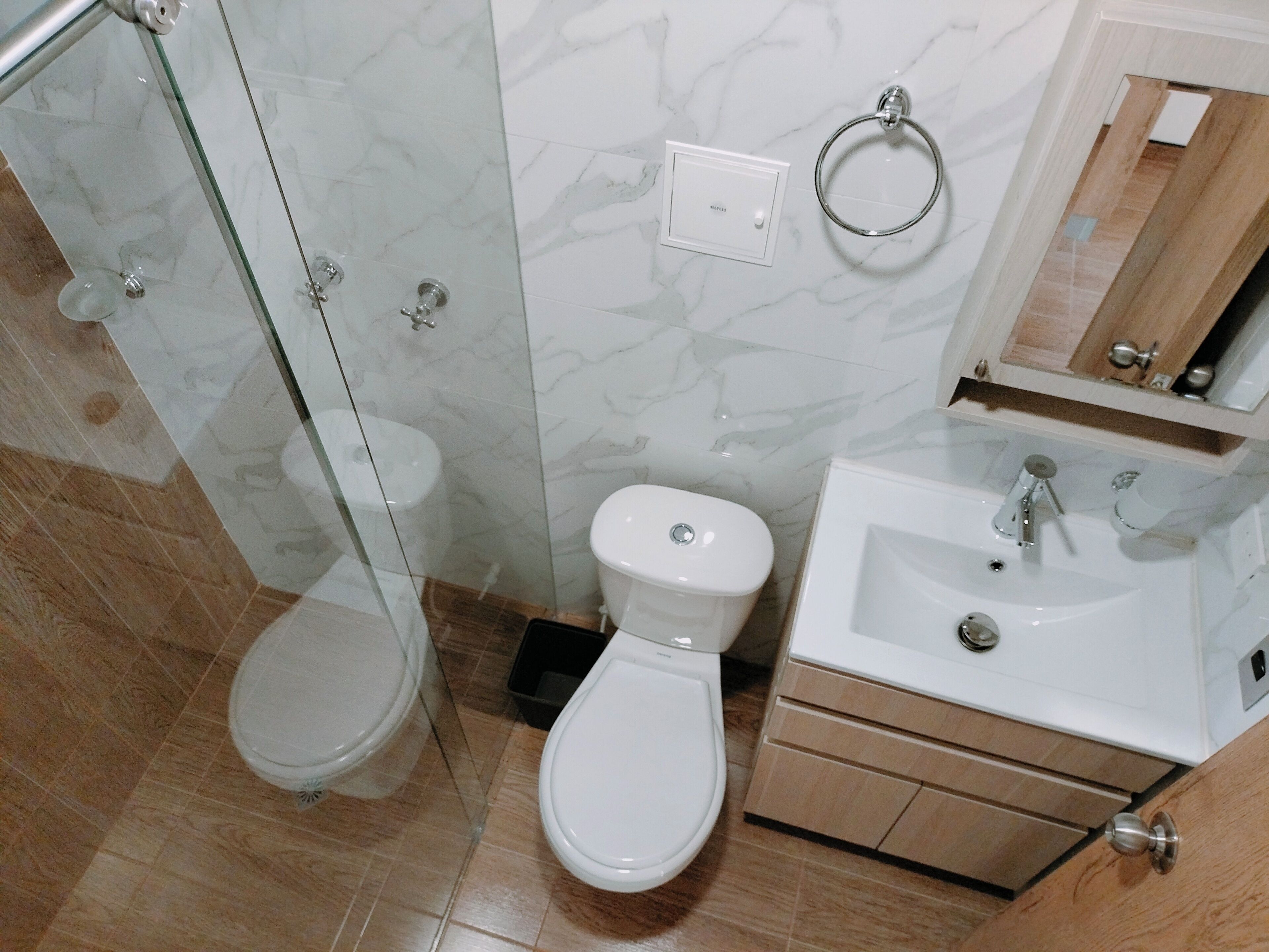 Une salle de bain avec une douche à parois de verre, des toilettes, un bidet et un lavabo avec un miroir au-dessus.