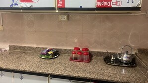 A kitchen counter with a plate of snacks, a set of red condiment containers, and a kettle. - Beit Baitk 1 (6th of October City)
