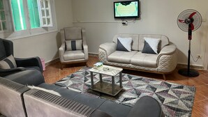 A living room with a sofa, armchair, and a coffee table. - Beit Baitk 1 (6th of October City)