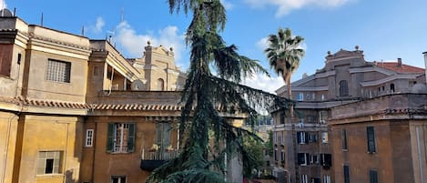Un patio con edificios de arquitectura tradicional, que incluyen balcones y ventanas.
