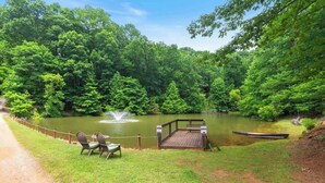A serene lakeside setting with a wooden deck, chairs, and a canoe. - Couples Carriage House Retreat - Wineries & Hiking (Dahlonega)
