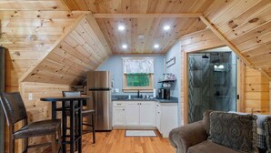 A cozy attic-style room with a dining area, kitchenette, and a sofa. - Couples Carriage House Retreat - Wineries & Hiking (Dahlonega)