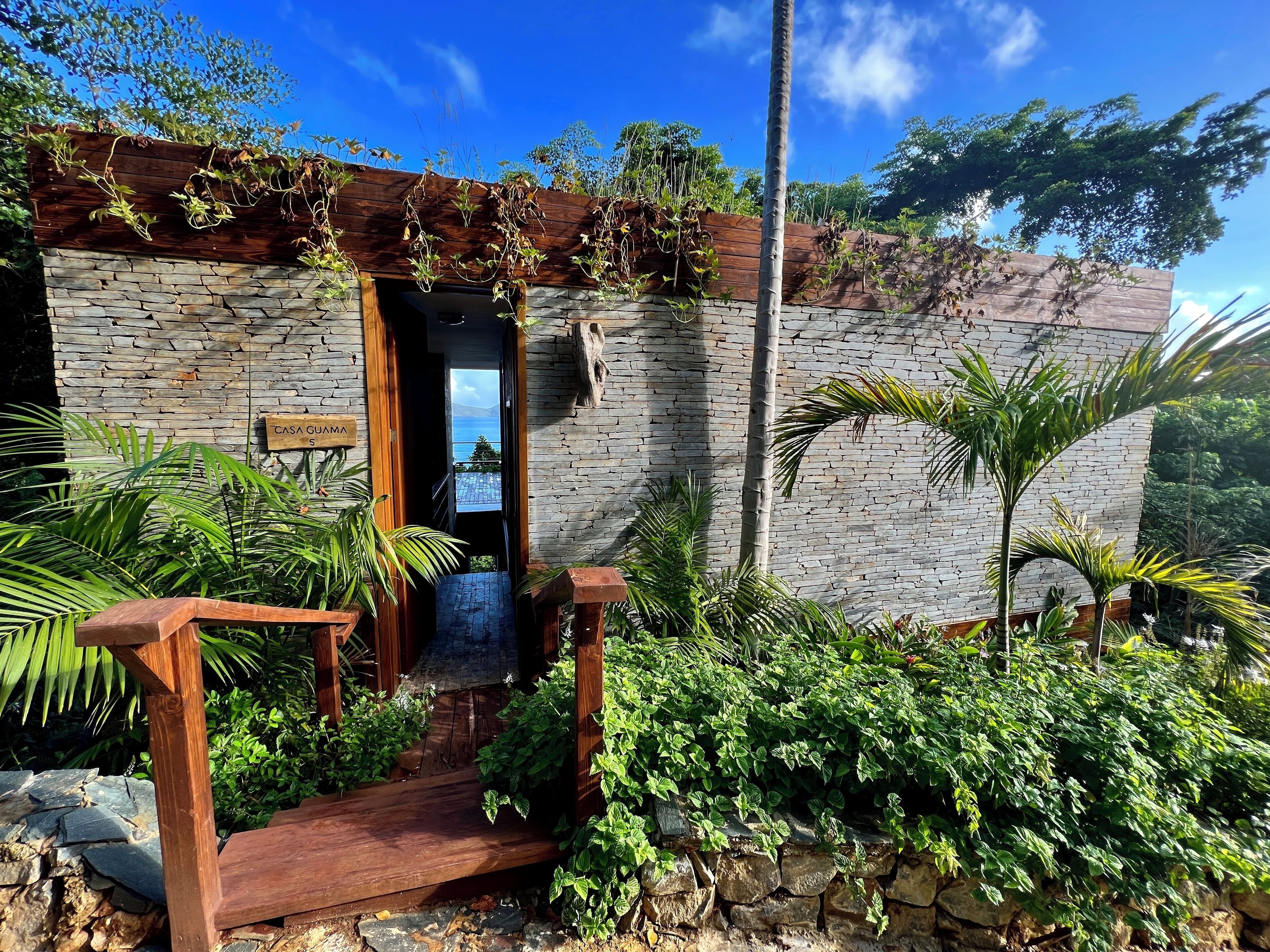 A stone building with a wooden staircase leading to a door marked "CASA CUJAMA."