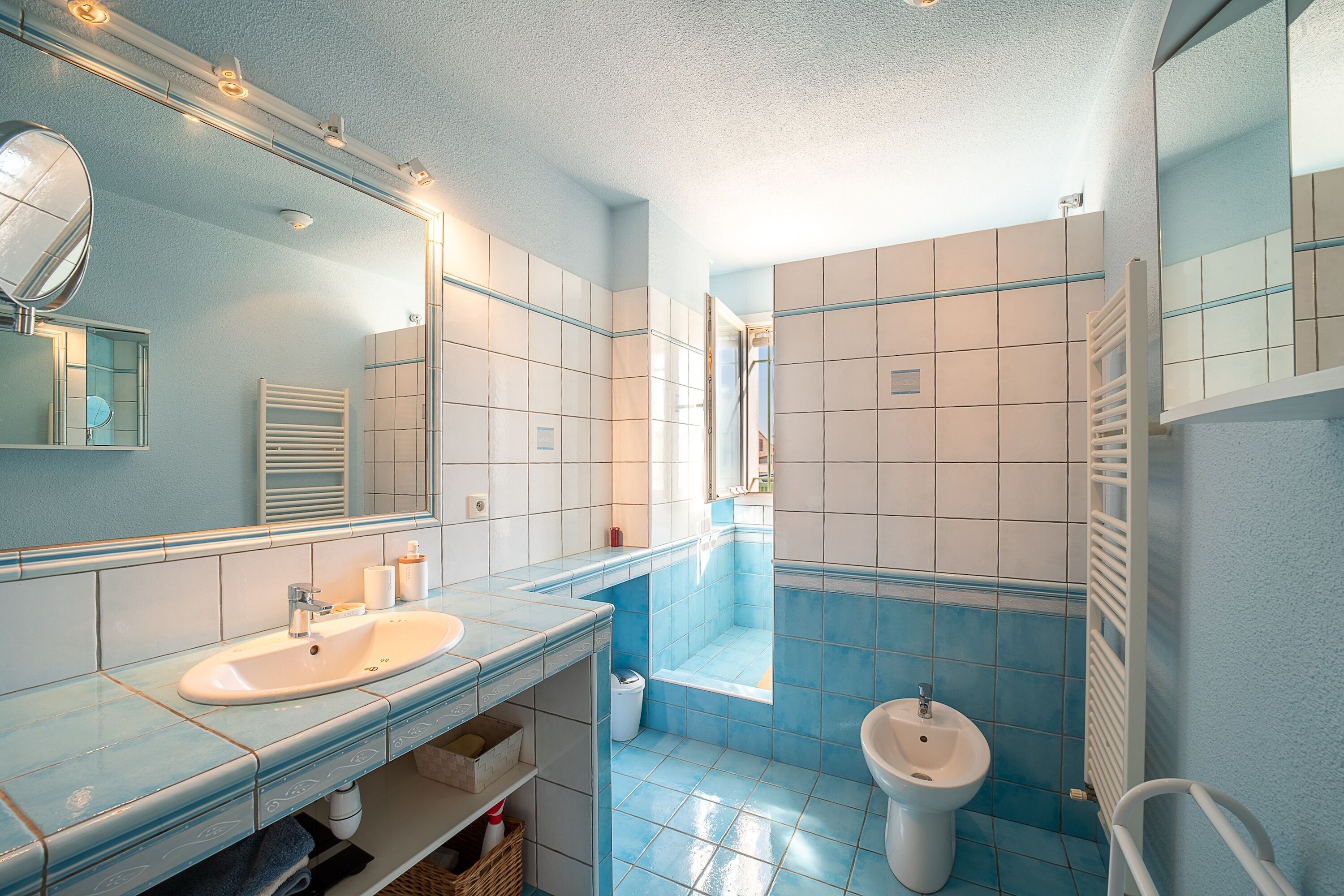 A bathroom with a sink, mirror, and toilet.