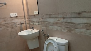 Un baño moderno con inodoro, lavamanos y espejo.