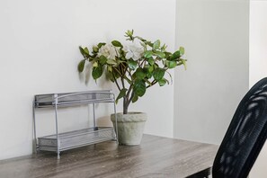 Une étagère en métal avec un pot de plante placé à côté.