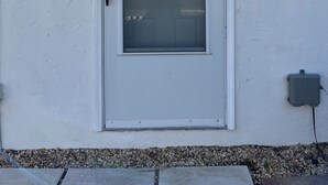 A white door with a glass panel, a small 'B' sign, and a utility box on the wall. - Quiet studio in New Port Richey Downtown. Apartment B (New Port Richey)