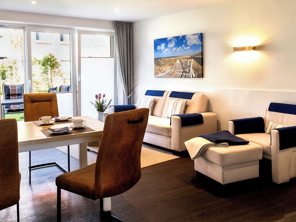 Un salon moderne avec un ensemble de canapés, une table à manger avec des chaises et un tableau accroché au mur.