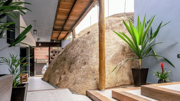 A modern interior with a large rock feature, wooden steps, and potted plants. - VELINN 2Secreto Hotel Boutique (Ilhabela)