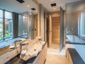 A modern bathroom with a large stone sink, two mirrors, a walk-in shower, and a bathtub. - Superior Chalet With Views (Rougemont)