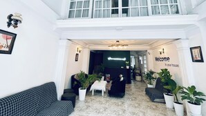 Eine geräumige Lobby mit hoher Decke, einem Empfangsschalter und einem freundlichen Willkommensschild.