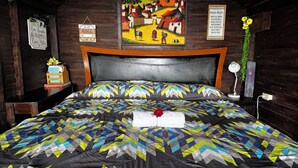 A wooden cabin-style room with a bed, a painting, and a sign on the wall. - Bistro La Petite (San Francisco Chinameca)