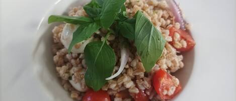 Un plato de arroz con tomates y albahaca.