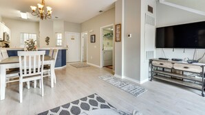 A modern kitchen with a dining area, a chandelier, and a large flat-screen TV. - Townhome 7 Mi to Disney Parks: Resort Pool Access! (Kissimmee)