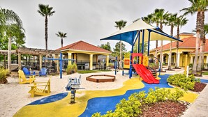 A playground with a slide, swings, and a sandbox. - Townhome 7 Mi to Disney Parks: Resort Pool Access! (Kissimmee)