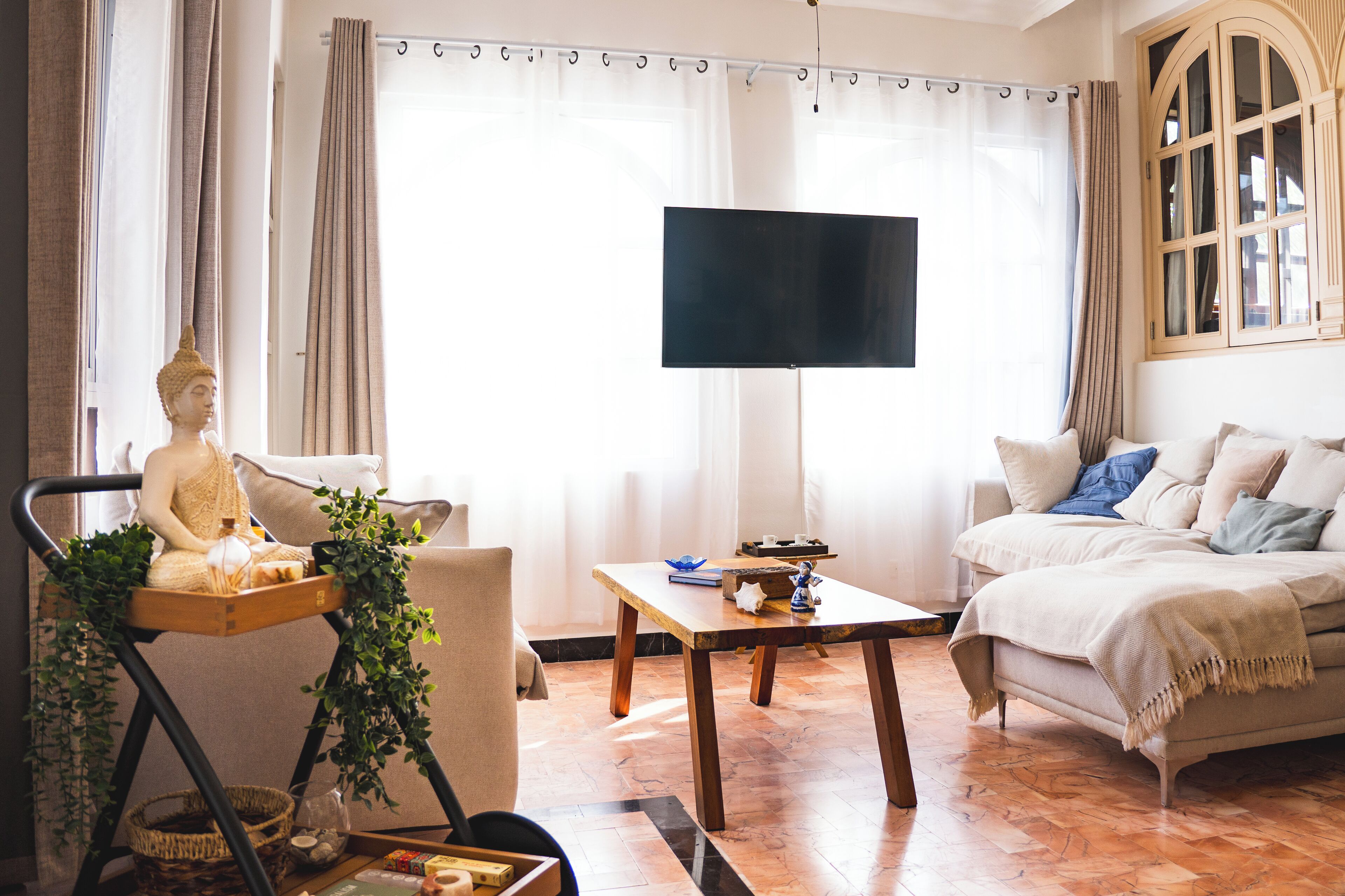A living room with a statue, a television, a sofa, and a coffee table.