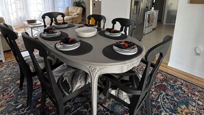 A dining area with a round table, black chairs, and a chandelier. - Spacious 3BR home with Heated Pool & WiFi! Great spot near beaches & shopping! (Port Charlotte)