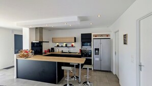 Una cocina moderna con una isla central, electrodomésticos integrados y un diseño minimalista.