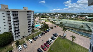 A high-rise building with a swimming pool and tennis courts. - Penthouse condo, Gulf and Intercostal views, Bonita Beach and Tennis Club (Bonita Springs)